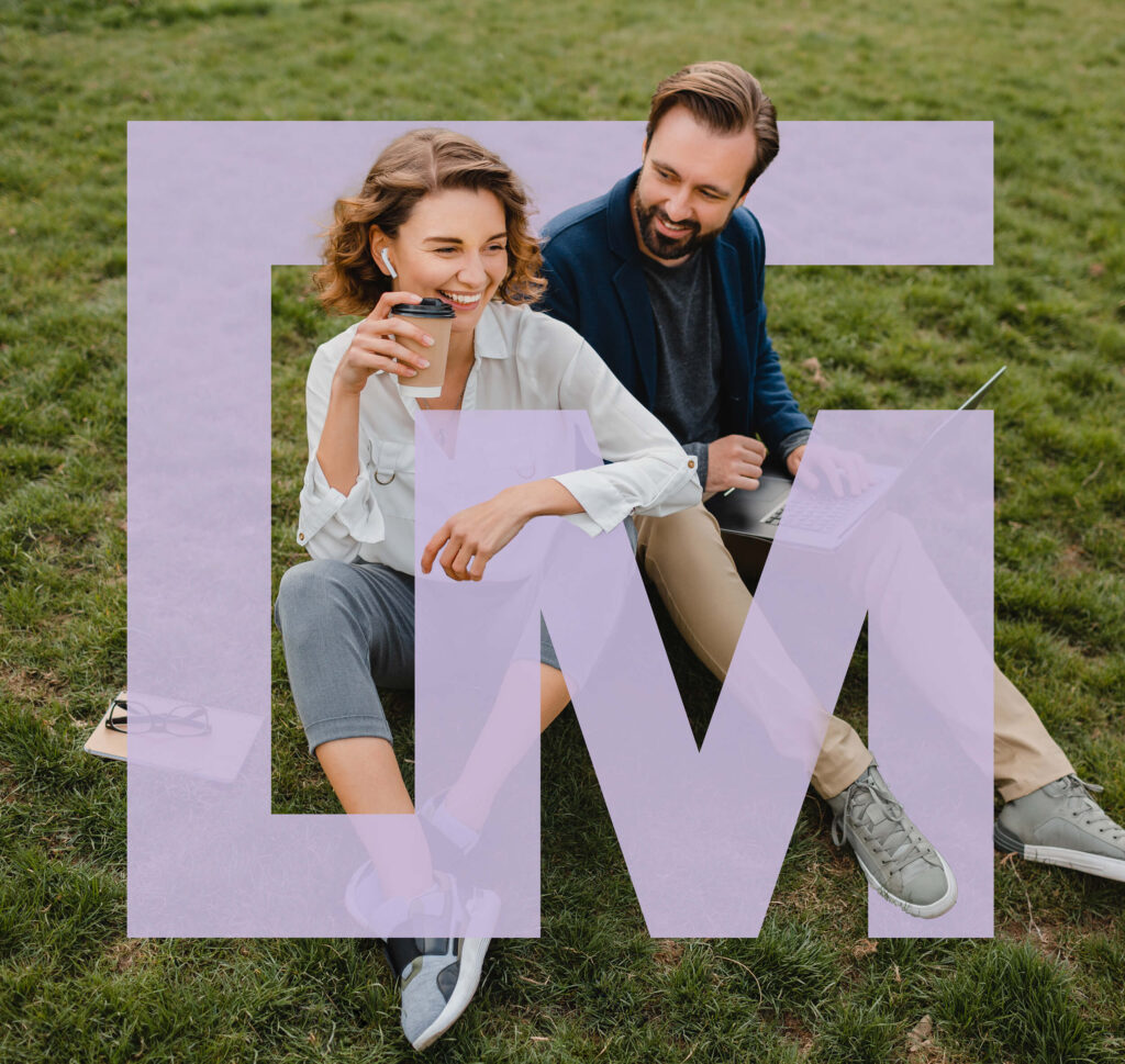 Couple assis dans l’herbe d’un parc, café à la main, avec le monogramme du Carré Mathieu